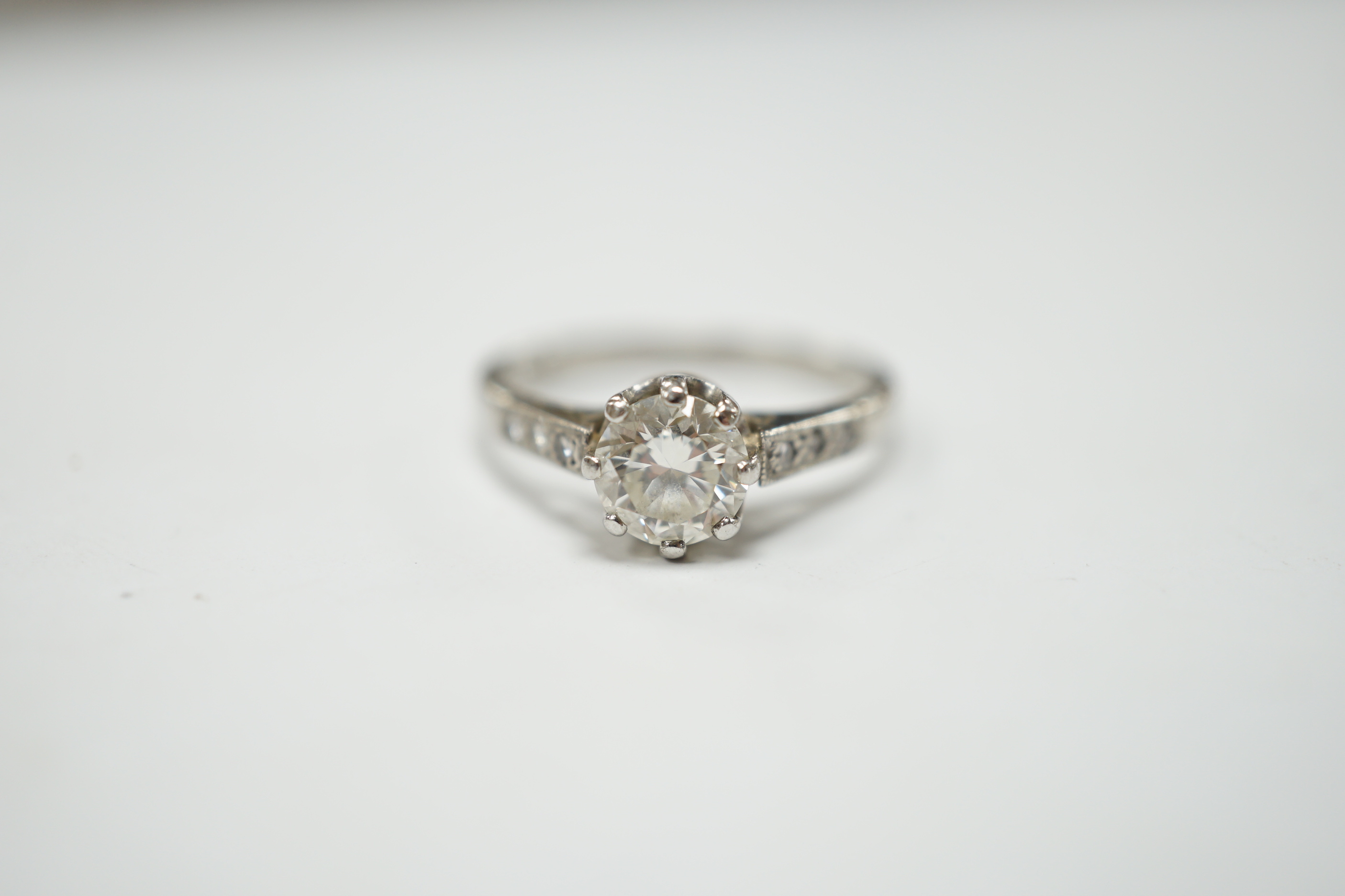 A platinum and single stone diamond set ring, with six stone diamond chip set shoulders, size P, gross weight 4.5 grams